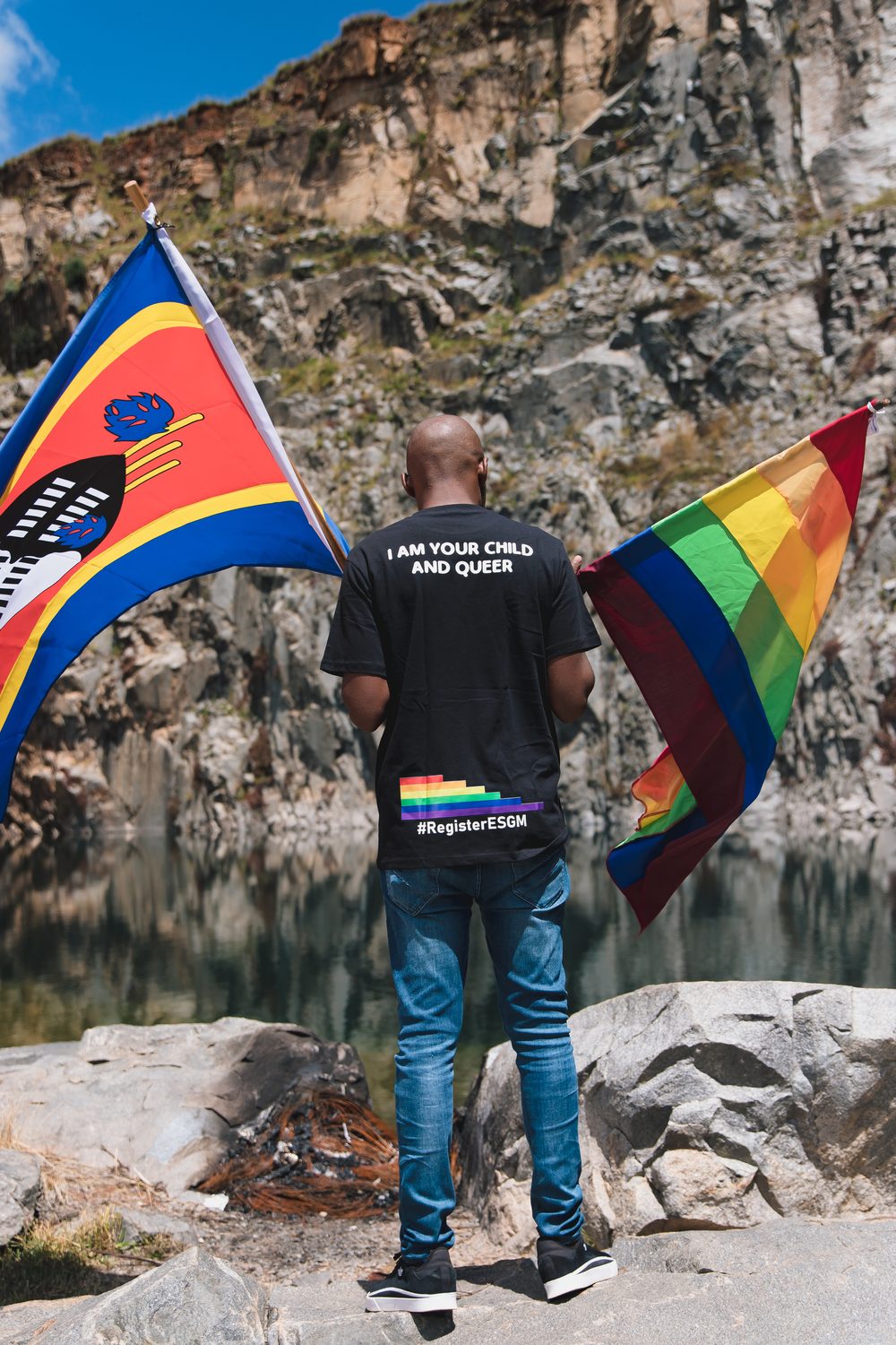 An ESGM member holds the Eswatini flag and the pride flag